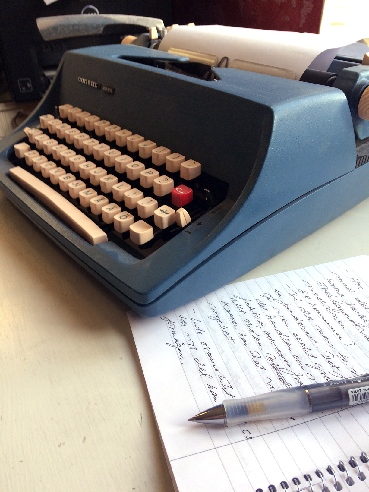 Skrivmaskin och block på ett skrivbord